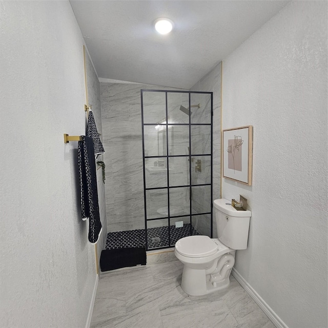 bathroom featuring tiled shower and toilet