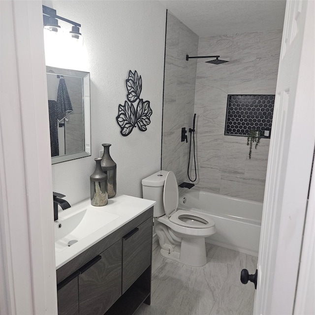 full bathroom featuring vanity, tiled shower / bath, and toilet