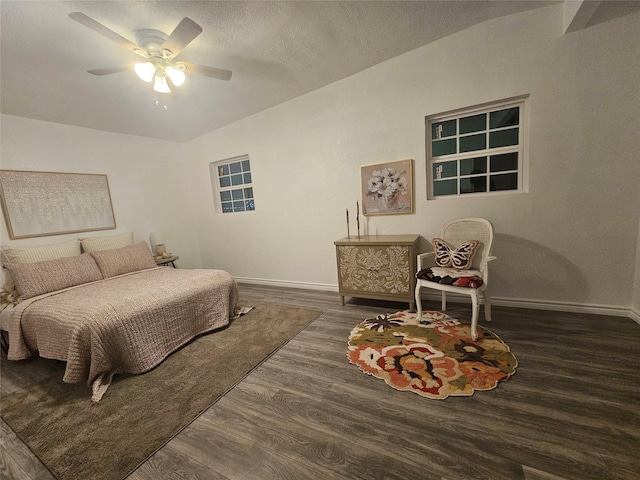 bedroom with ceiling fan, a textured ceiling, and dark hardwood / wood-style flooring