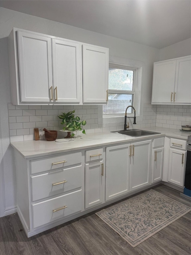 kitchen featuring tasteful backsplash, sink, dark wood-type flooring, and white cabinets