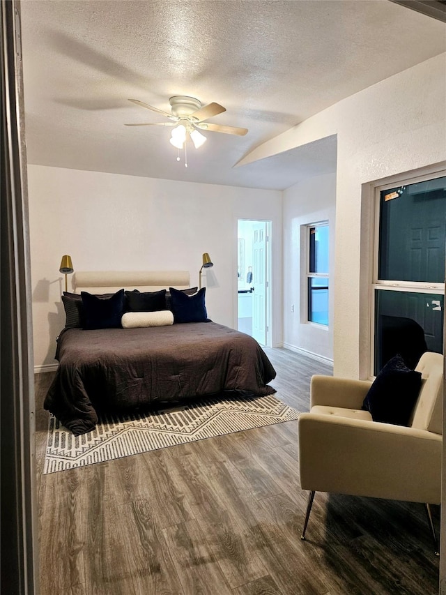 bedroom featuring ceiling fan, wood-type flooring, and a textured ceiling