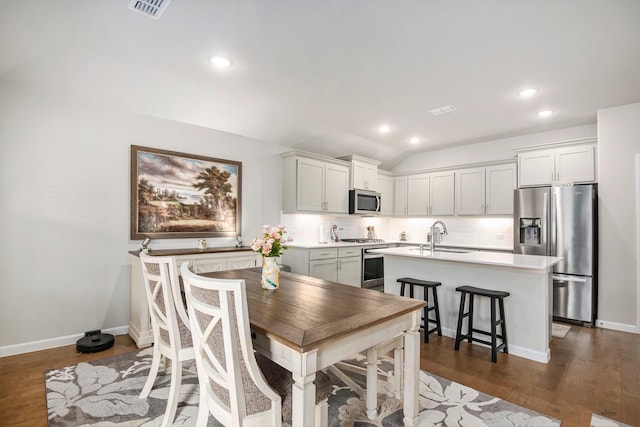 dining space featuring sink, dark hardwood / wood-style flooring, and lofted ceiling