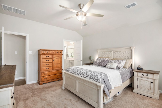 bedroom featuring vaulted ceiling, light colored carpet, ensuite bath, and ceiling fan