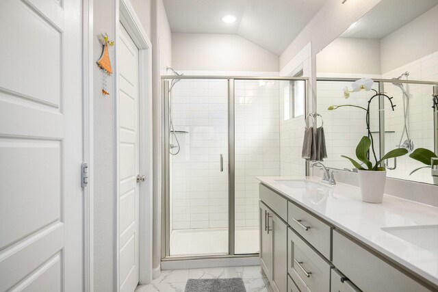 bathroom with vanity, vaulted ceiling, and a shower with door