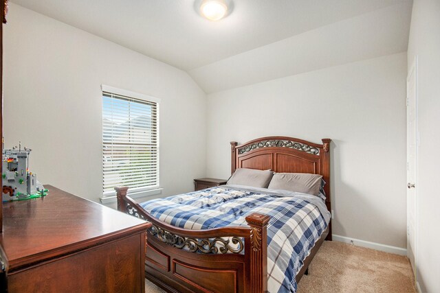 bedroom with carpet floors and lofted ceiling