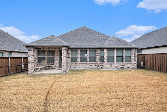 rear view of property featuring a patio area and a lawn