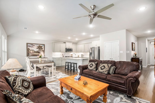 living room with sink, ceiling fan, vaulted ceiling, and light hardwood / wood-style floors