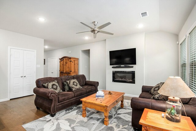 living room with hardwood / wood-style floors, vaulted ceiling, and ceiling fan