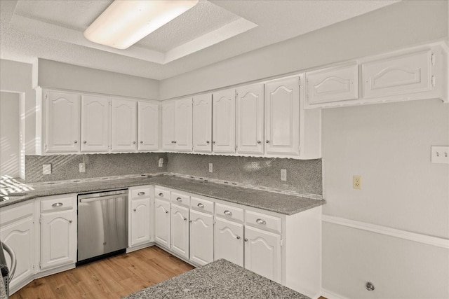 kitchen with dishwasher, white cabinets, light wood-type flooring, tasteful backsplash, and stone countertops