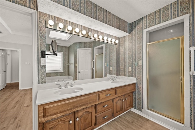 bathroom featuring hardwood / wood-style floors, vanity, a textured ceiling, and shower with separate bathtub