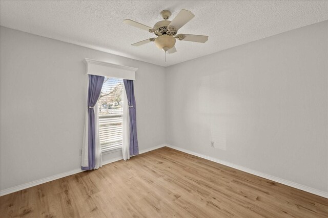 empty room with a textured ceiling, light wood-type flooring, and ceiling fan