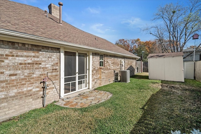 view of yard featuring central AC unit and a storage shed