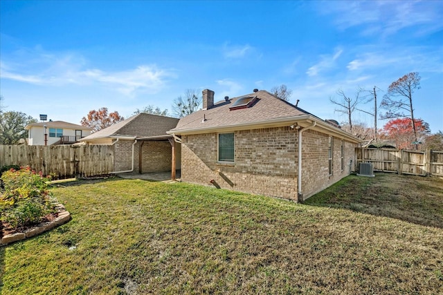 rear view of house featuring a lawn and central air condition unit