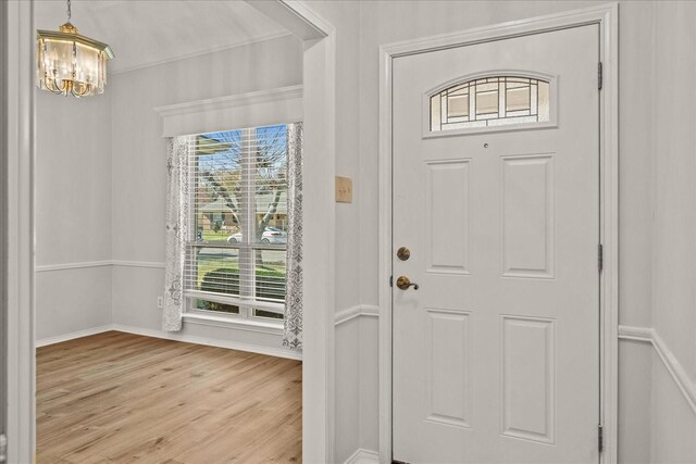 entrance foyer featuring light hardwood / wood-style floors and a notable chandelier