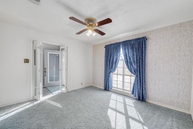 carpeted spare room featuring ceiling fan and a textured ceiling