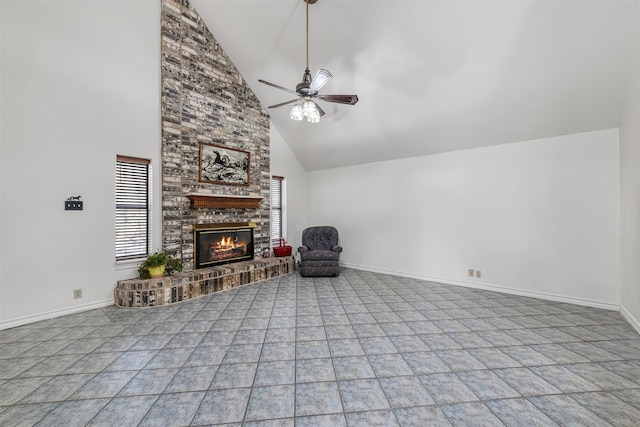 unfurnished living room featuring a brick fireplace, plenty of natural light, high vaulted ceiling, and ceiling fan