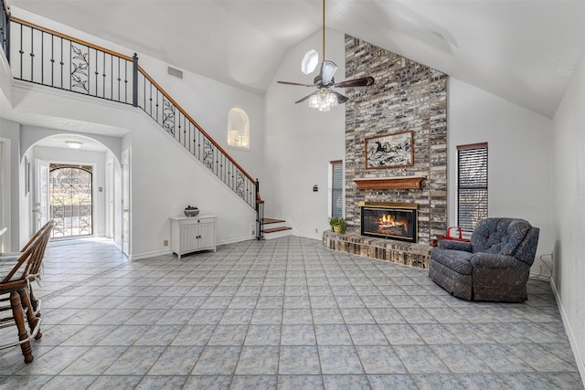 living room featuring ceiling fan, high vaulted ceiling, light tile patterned flooring, and a fireplace