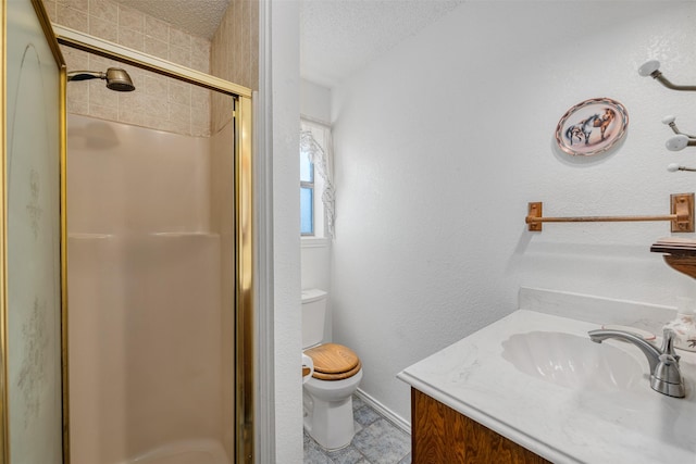 bathroom featuring vanity, toilet, an enclosed shower, and a textured ceiling