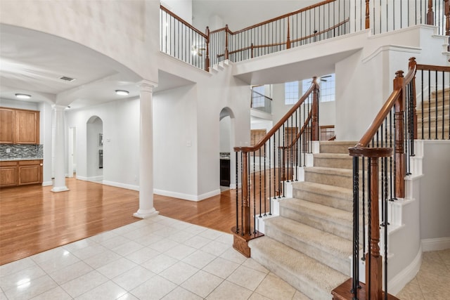 tiled foyer entrance featuring ornate columns and a high ceiling