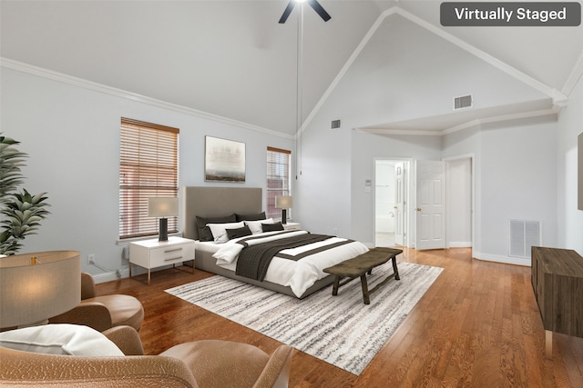 bedroom with hardwood / wood-style flooring, ornamental molding, ceiling fan, and high vaulted ceiling