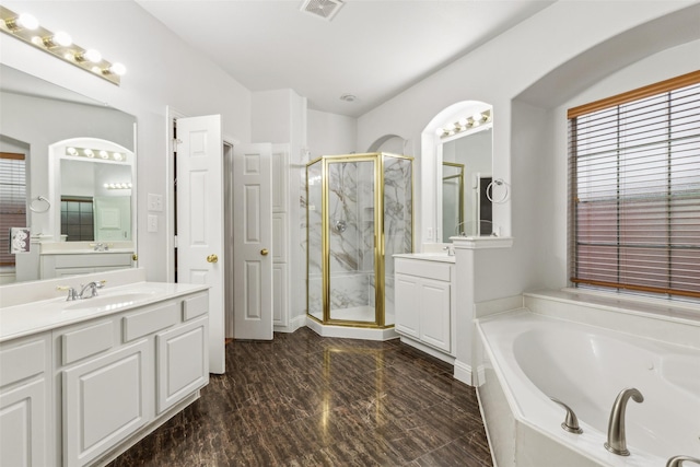 bathroom with vanity and shower with separate bathtub