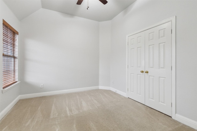 carpeted empty room featuring ceiling fan and lofted ceiling