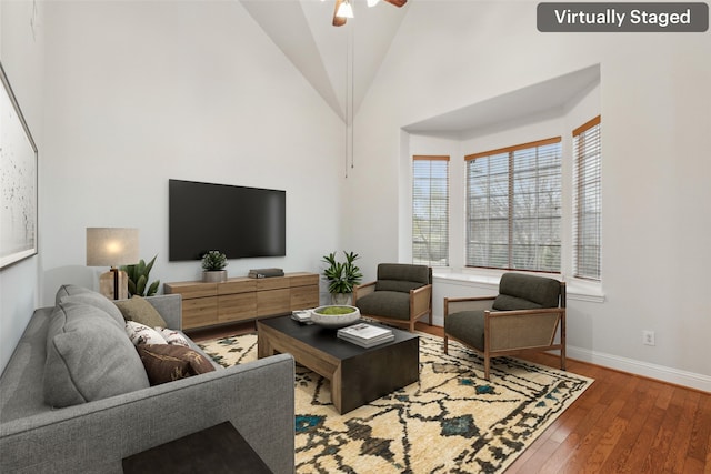 living room featuring ceiling fan, wood-type flooring, and high vaulted ceiling