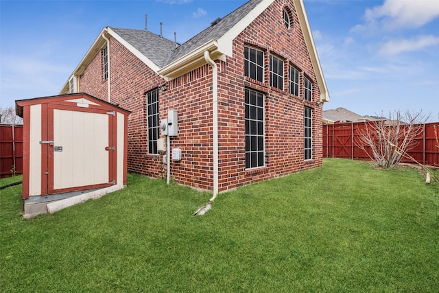 rear view of property featuring a yard and a storage shed