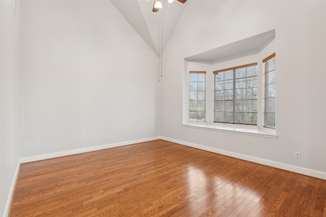 empty room featuring ceiling fan, hardwood / wood-style floors, and vaulted ceiling