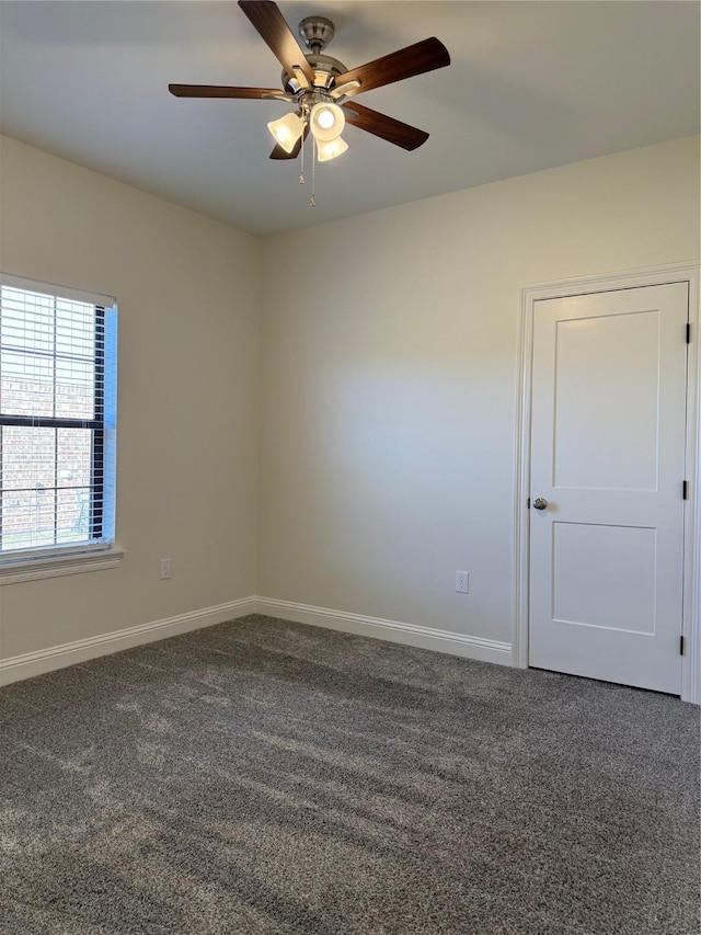 unfurnished room featuring dark colored carpet and ceiling fan