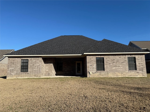 rear view of house featuring a lawn