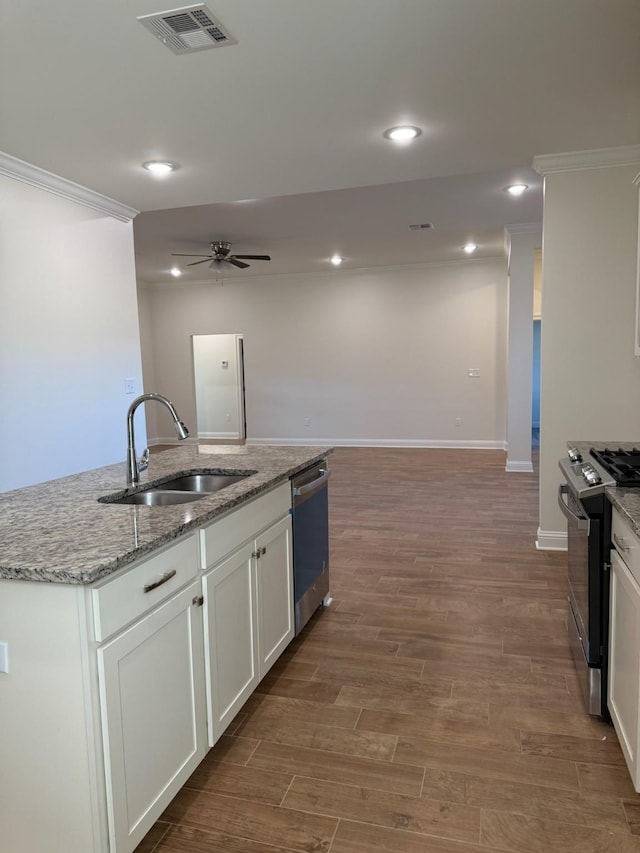 kitchen featuring appliances with stainless steel finishes, dark hardwood / wood-style floors, sink, white cabinets, and a kitchen island with sink