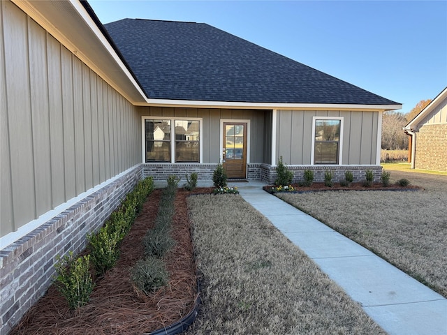 view of exterior entry with a yard