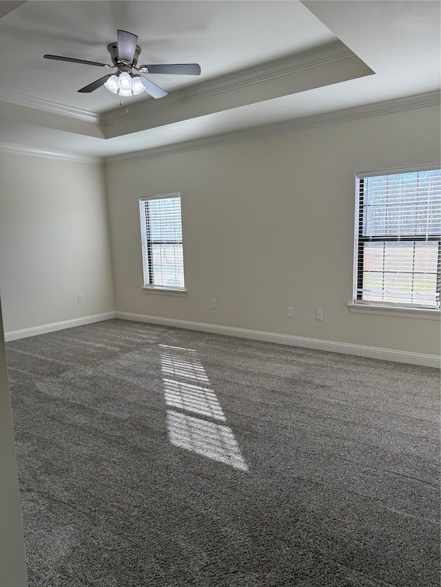 unfurnished room with crown molding, ceiling fan, a tray ceiling, and dark carpet