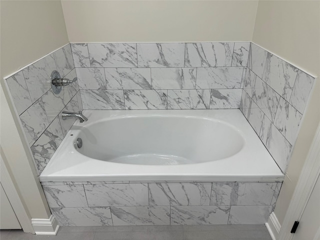 bathroom with tile patterned flooring and a relaxing tiled tub