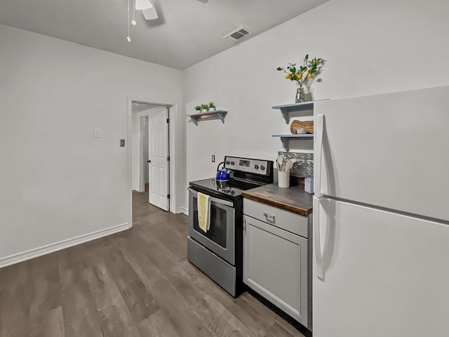 kitchen featuring white refrigerator, white cabinetry, hardwood / wood-style floors, butcher block countertops, and stainless steel electric range oven