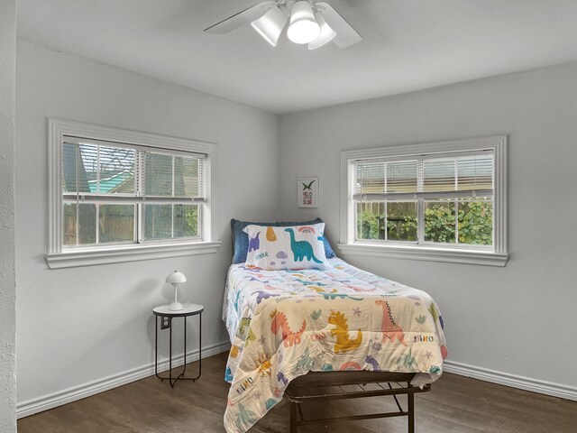 bedroom with multiple windows, ceiling fan, and dark wood-type flooring