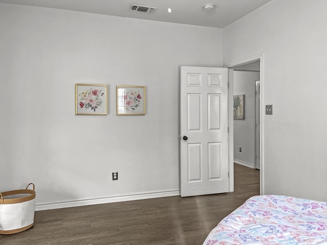 bedroom with dark hardwood / wood-style floors