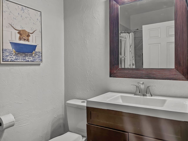 bathroom with a shower with curtain, vanity, and toilet