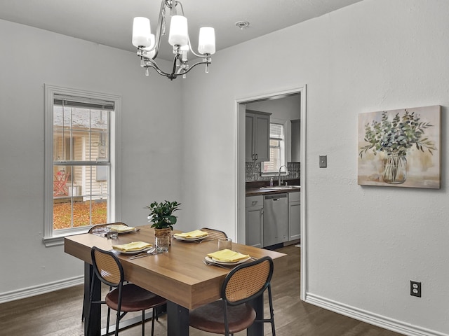 dining area with dark hardwood / wood-style flooring, sink, and an inviting chandelier