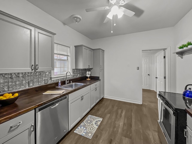 kitchen featuring ceiling fan, sink, dark hardwood / wood-style floors, decorative backsplash, and appliances with stainless steel finishes