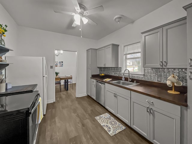 kitchen featuring gray cabinetry, sink, tasteful backsplash, butcher block countertops, and stainless steel appliances