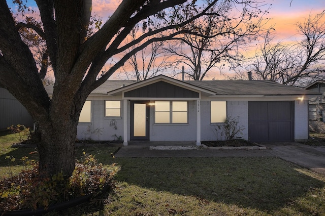 ranch-style home with a yard and a garage