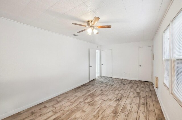 unfurnished room with ceiling fan and light wood-type flooring