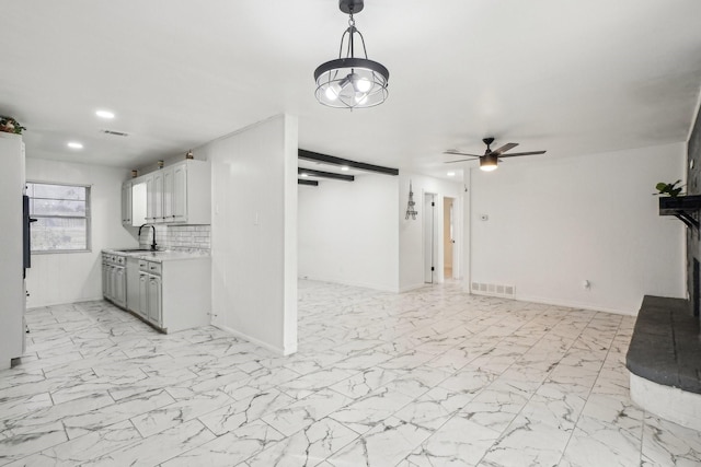 kitchen with tasteful backsplash, sink, and ceiling fan