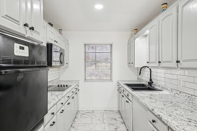 kitchen with white cabinetry, sink, and black appliances