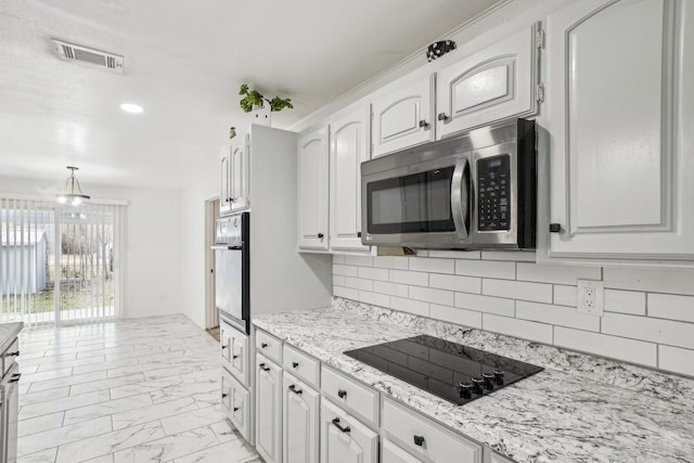 kitchen with black electric stovetop, white cabinets, wall oven, and light stone counters