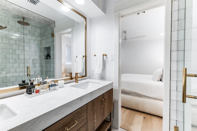 bathroom with vanity, hardwood / wood-style flooring, an enclosed shower, and ceiling fan