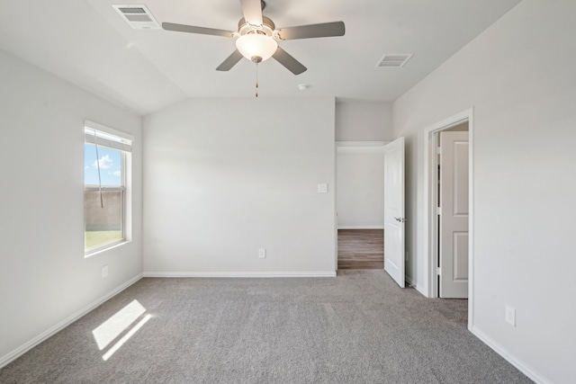 carpeted spare room featuring ceiling fan and lofted ceiling