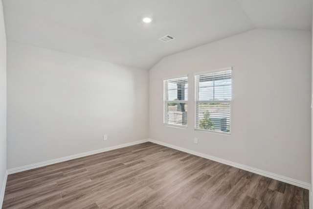 empty room with dark hardwood / wood-style flooring and lofted ceiling